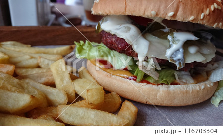Juicy Cheeseburger with Fries on Wooden Board 116703304