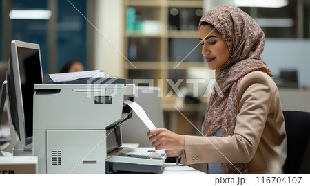 Dedicated and ambitious, a Muslim woman thrives in the fast-paced office environment. 116704107