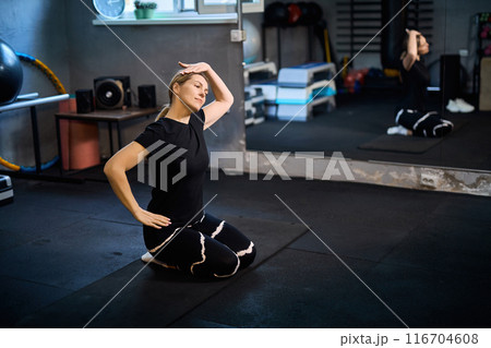 Young attractive sportive woman wearing activewear doing exercises at GYM, 116704608