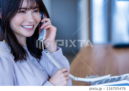 オフィスで固定電話で話すミドルの女性 116705476
