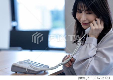 オフィスで固定電話で話すミドルの女性 オフィスで固定電話で話すミドルの女性 116705483