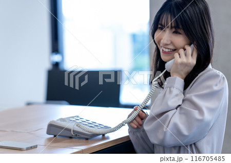 オフィスで固定電話で話すミドルの女性 116705485