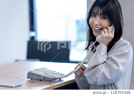 オフィスで固定電話で話すミドルの女性 オフィスで固定電話で話すミドルの女性 116705486
