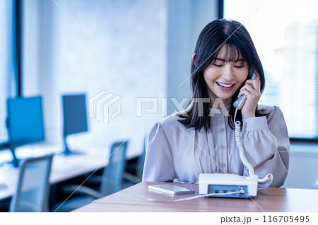 オフィスで固定電話で話すミドルの女性 オフィスで固定電話で話すミドルの女性 116705495