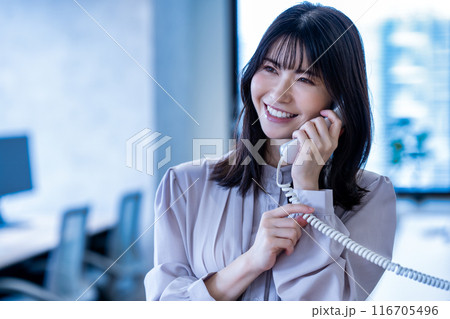 オフィスで固定電話で話すミドルの女性 オフィスで固定電話で話すミドルの女性 116705496