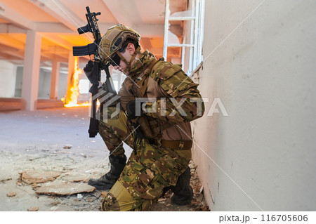 Soldier in action near window changing magazine and take cover Soldier in action near window changing magazine and take cover 116705606