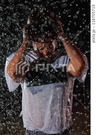 American Football Field: Lonely Athlete Warrior Standing on a Field Holds his Helmet and Ready to Play. Player Preparing to Run, Attack and Score Touchdown. Rainy Night with Dramatic Fog, Blue Light American Football Field: Lonely Athlete Warrior Standing on a Field Holds his Helmet and Ready to Play. Player Preparing to Run, Attack and Score Touchdown. Rainy Night with Dramatic Fog, Blue Light 116705718