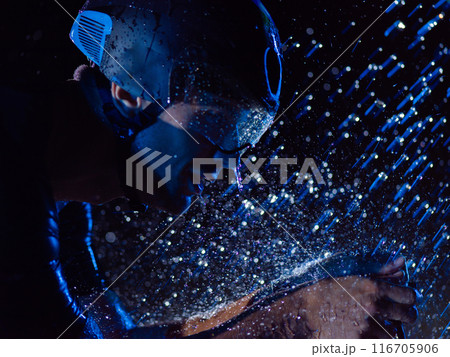 A triathlete braving the rain as he cycles through the night, preparing himself for the upcoming marathon. The blurred raindrops in the foreground and the dark, moody atmosphere in the background add 116705906