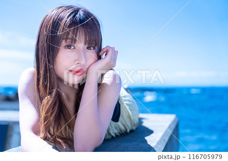 防波堤に寝転んで海を満喫する若い女性 防波堤に寝転んで海を満喫する若い女性 116705979
