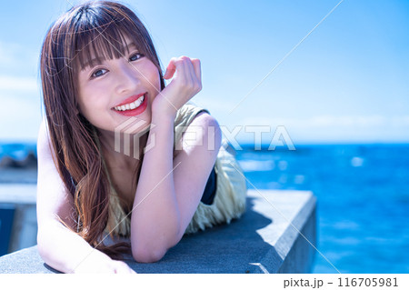 防波堤に寝転んで海を満喫する若い女性 防波堤に寝転んで海を満喫する若い女性 116705981