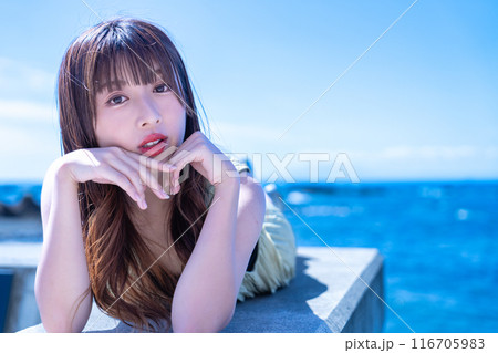 防波堤に寝転んで海を満喫する若い女性 防波堤に寝転んで海を満喫する若い女性 116705983
