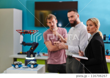 A group of students working together in a laboratory, dedicated to exploring the aerodynamic capabilities of a drone 116706267