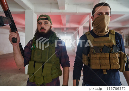 An abandoned building serves as the stronghold for a team of terrorists, fiercely guarding their occupied territory with guns and military equipment 116706372