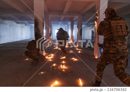 A group of professional soldiers bravely executes a dangerous rescue mission, surrounded by fire in a perilous building. 116706382