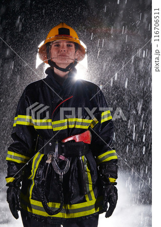 A determined female firefighter in a professional uniform striding through the dangerous, rainy night on a daring rescue mission, showcasing her unwavering bravery and commitment to saving lives. A determined female firefighter in a professional uniform striding through the dangerous, rainy night on a daring rescue mission, showcasing her unwavering bravery and commitment to saving lives. 116706511