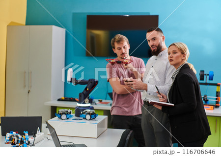 A group of students working together in a laboratory, dedicated to exploring the aerodynamic capabilities of a drone A group of students working together in a laboratory, dedicated to exploring the aerodynamic capabilities of a drone 116706646