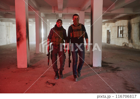 An abandoned building serves as the stronghold for a team of terrorists, fiercely guarding their occupied territory with guns and military equipment An abandoned building serves as the stronghold for a team of terrorists, fiercely guarding their occupied territory with guns and military equipment 116706817