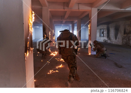 A group of professional soldiers bravely executes a dangerous rescue mission, surrounded by fire in a perilous building. 116706824