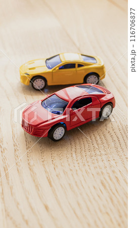 木製のテーブルの上に赤と黄色のミニカー 116706877