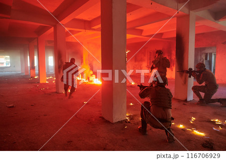 A group of professional soldiers bravely executes a dangerous rescue mission, surrounded by fire in a perilous building. 116706929