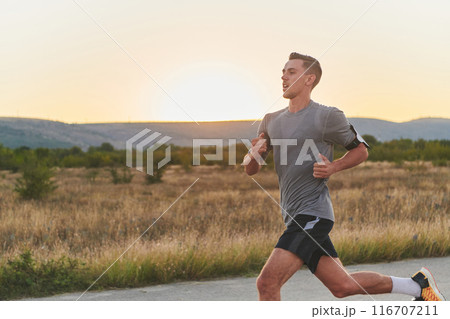 A young handsome man running in the early morning hours, driven by his commitment to health and fitness A young handsome man running in the early morning hours, driven by his commitment to health and fitness 116707211