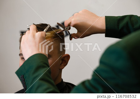 Haircut alignment of the contour of the head with scissors. Short haircut in the barbershop. Haircut alignment of the contour of the head with scissors. Short haircut in the barbershop. 116708532