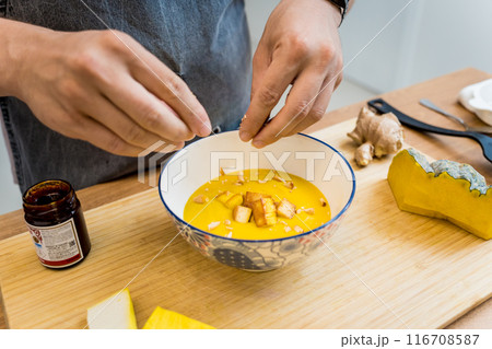 Chef at the kitchen preparing pumpkin porridge with tofu and vegetables 116708587