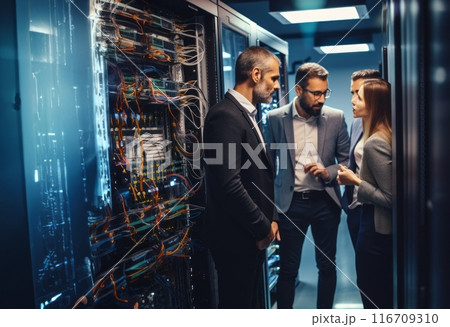 A group of engineers engages in a discussion about technical issues while situated in a modern server room, collaborating to find solutions and ensure the smooth operation of the technology 116709310