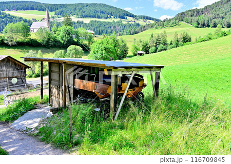 牧草地小屋にひっそりと置かれた馬車 116709845