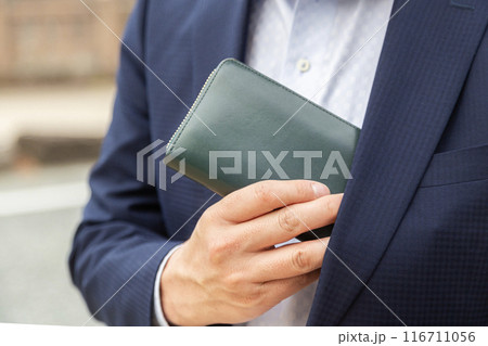 胸ポケットから財布を取り出すサラリーマン 胸ポケットから財布を取り出すサラリーマン 116711056