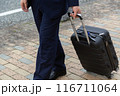 スーツケースを持って歩道を歩くビジネスマン 116711064