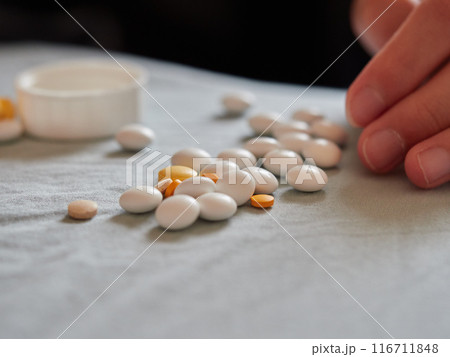 たくさんの各種類の薬品の錠剤の様子と子供の手 116711848