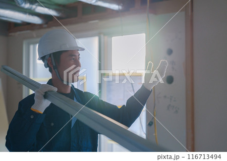 建設現場で資材を運ぶ男性の職人 建設現場で資材を運ぶ男性の職人 116713494