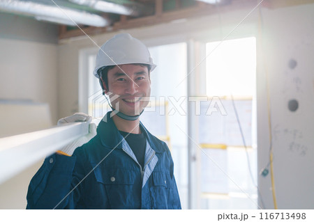 建設現場で資材を運ぶ男性の職人 116713498