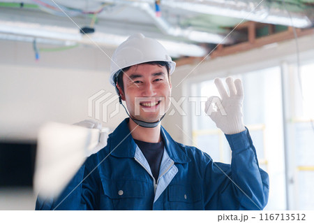 建設現場で資材を運ぶ男性の職人 116713512