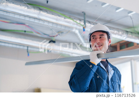 建設現場で資材を運ぶ男性の職人 116713526