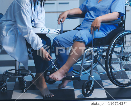 Asian young professional successful friendly female nurse in blue hospital uniform helping supporting physical therapy senior old pensioner unhealthy injury woman patient walking via four legs walker. Asian young professional successful friendly female nurse in blue hospital uniform helping supporting physical therapy senior old pensioner unhealthy injury woman patient walking via four legs walker. 116714374