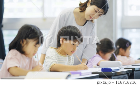 勉強をする小学生に指導する教師 116716216