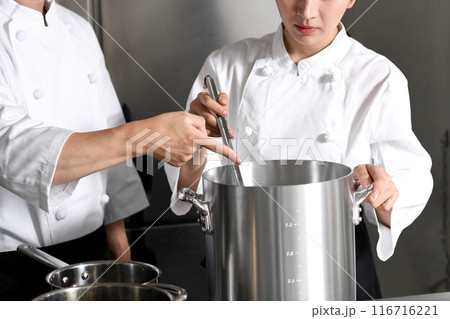 厨房で調理する若いアジア人の男女の調理師 厨房で調理する若いアジア人の男女の調理師 116716221
