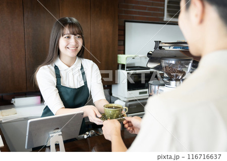 お客さんにコーヒーを渡すカフェの女性店員 116716637