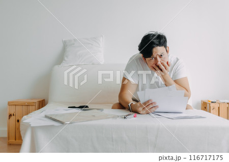 Man feeling serious with the paper works and loaning bills account. 116717175