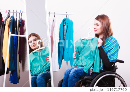 handicapped girl on wheelchair choosing clothes handicapped girl on wheelchair choosing clothes 116717760