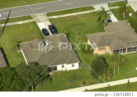 Aerial view of typical contemporary american private house with roof top covered with asphalt shingles and green lawn on yard Aerial view of typical contemporary american private house with roof top covered with asphalt shingles and green lawn on yard 116718851