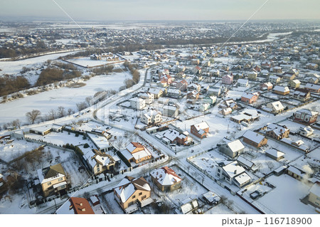 Aerial view of residential houses with snow covered roofops in suburban rural town area in winter 116718900