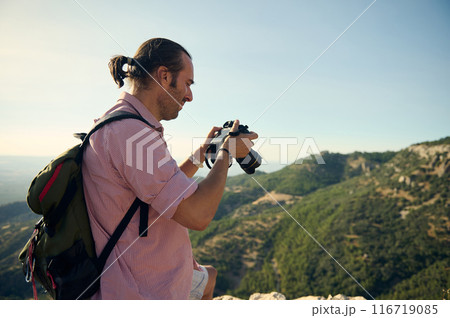 Male photographer exploring nature and taking photos in mountainous landscape 116719085
