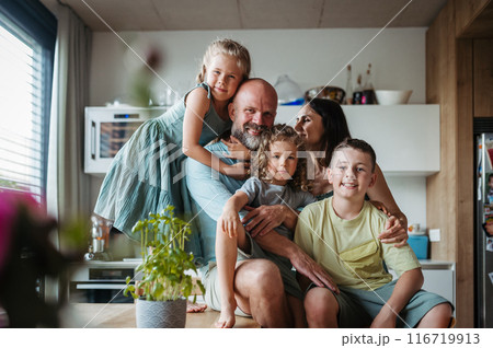 Cheerful family with three kids together in kitchen. Perfect family moment, bonding. Cheerful family with three kids together in kitchen. Perfect family moment, bonding. 116719913