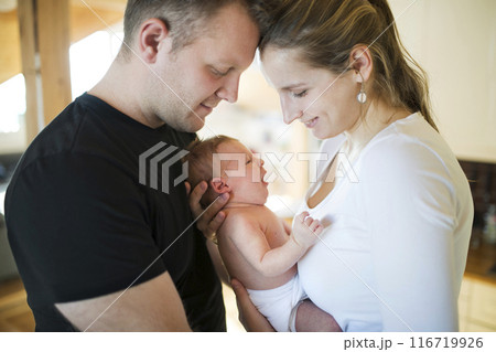 New parents holding newborn baby girl. Unconditional paternal love, idyllic family moment. New parents holding newborn baby girl. Unconditional paternal love, idyllic family moment. 116719926