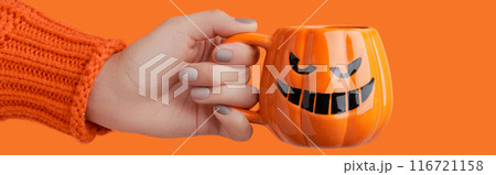 Cappuccino latte coffee in pumpkin cup on orange background. Halloween celebration concept Cappuccino latte coffee in pumpkin cup on orange background. Halloween celebration concept 116721158