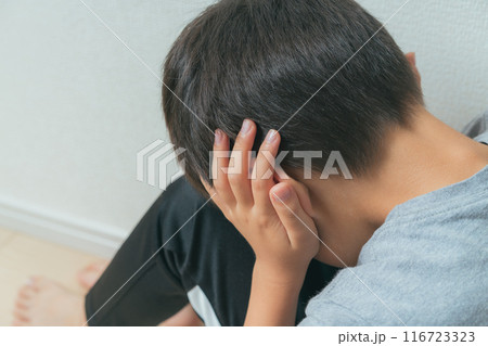 手で耳をふさいでうつむく男の子 116723323