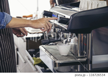 Close up hands coffee barista man make hot cup espresso shot from coffee machine. Cappuccino with milk in italian coffee shop cafe. Close up hands of barista use machine make black drinking hot cup Close up hands coffee barista man make hot cup espresso shot from coffee machine. Cappuccino with milk in italian coffee shop cafe. Close up hands of barista use machine make black drinking hot cup 116726534